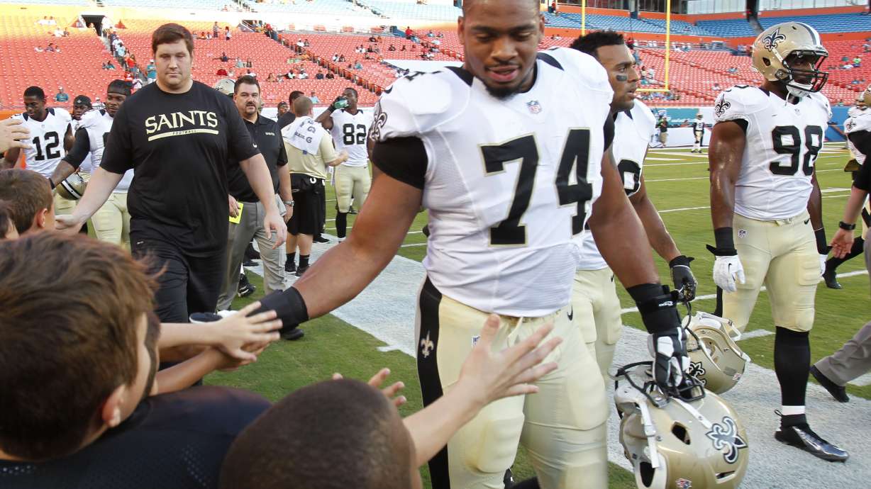 FILE - New Orleans Saints defensive end Glenn Foster Jr. (74) greets fans after practice before an NFL preseason football game against the Miami Dolphins, Thursday, Aug. 29, 2013, in Miami Gardens, Fla.