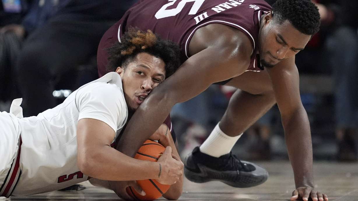 Texas Tech forward Darrion Williams (5) and Texas A&M forward Henry Coleman III (15) scramble to control the ball in the first half of an NCAA college basketball game in Fort Worth, Texas, Sunday, Dec. 8, 2024.