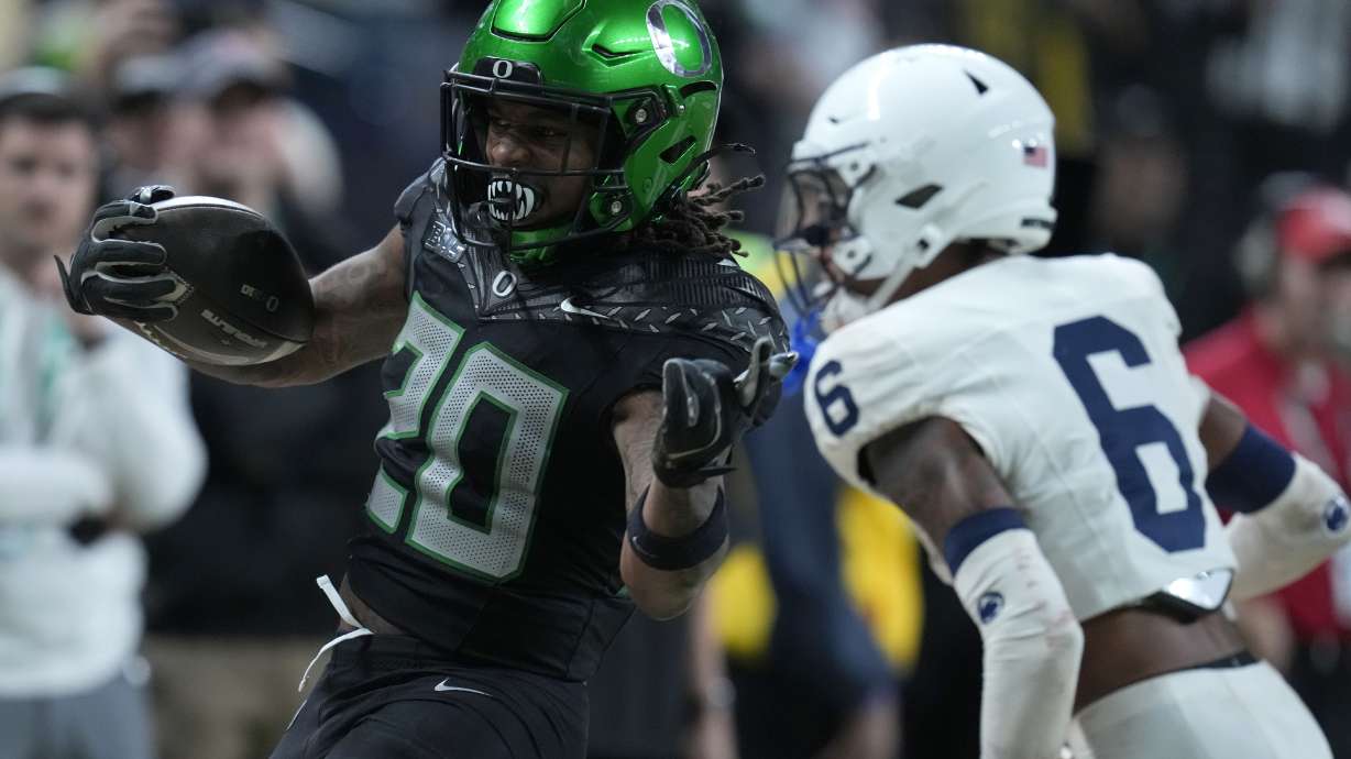 Oregon running back Jordan James (20) runs from Penn State safety Zakee Wheatley (6) during the second half of the Big Ten championship NCAA college football game, Saturday, Dec. 7, 2024, in Indianapolis.