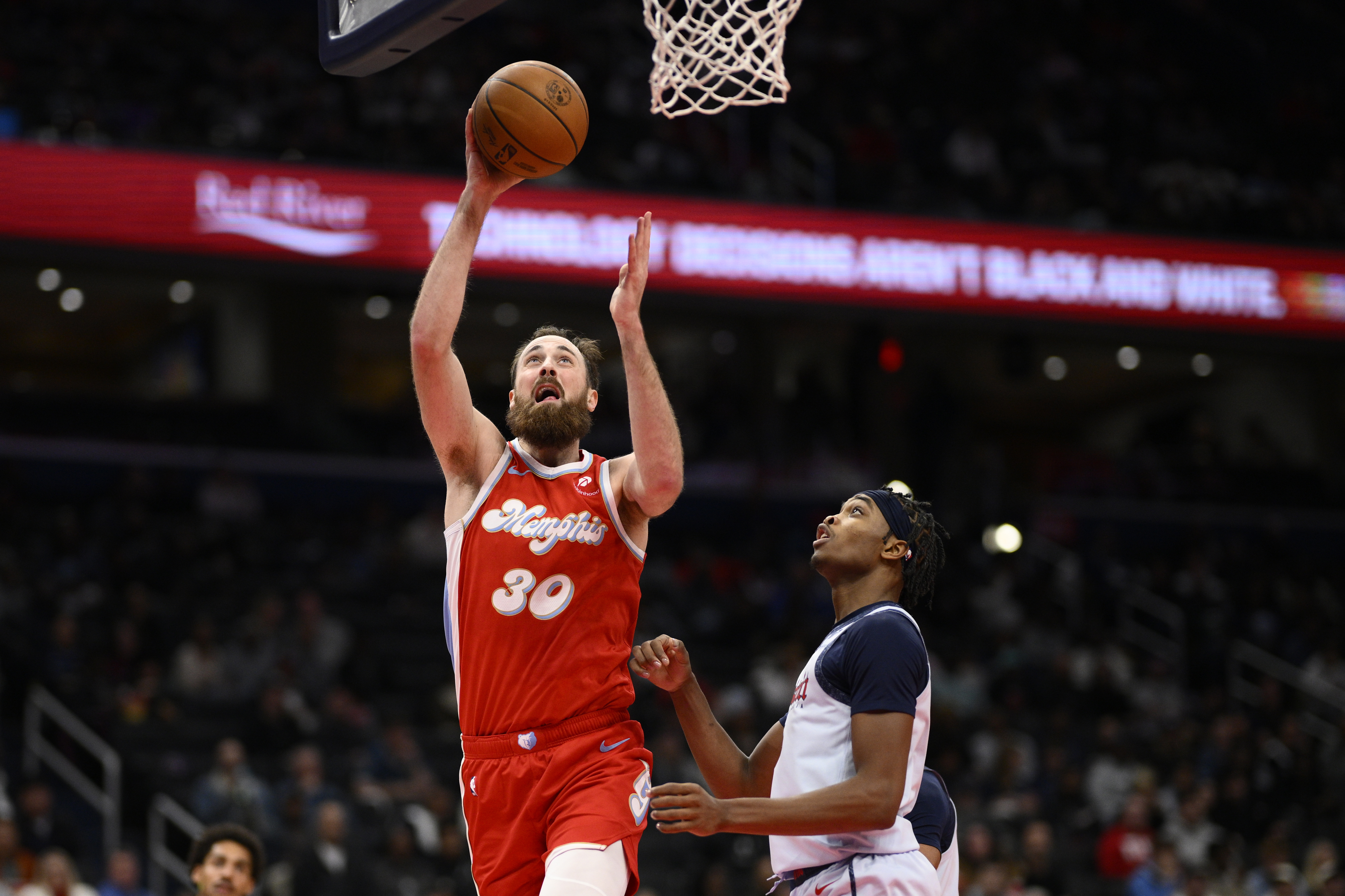 Memphis Grizzlies center Jay Huff (30) goes to the basket past Washington Wizards guard Bilal Coulibaly, right, during the first half of an NBA basketball game, Sunday, Dec. 8, 2024, in Washington.
