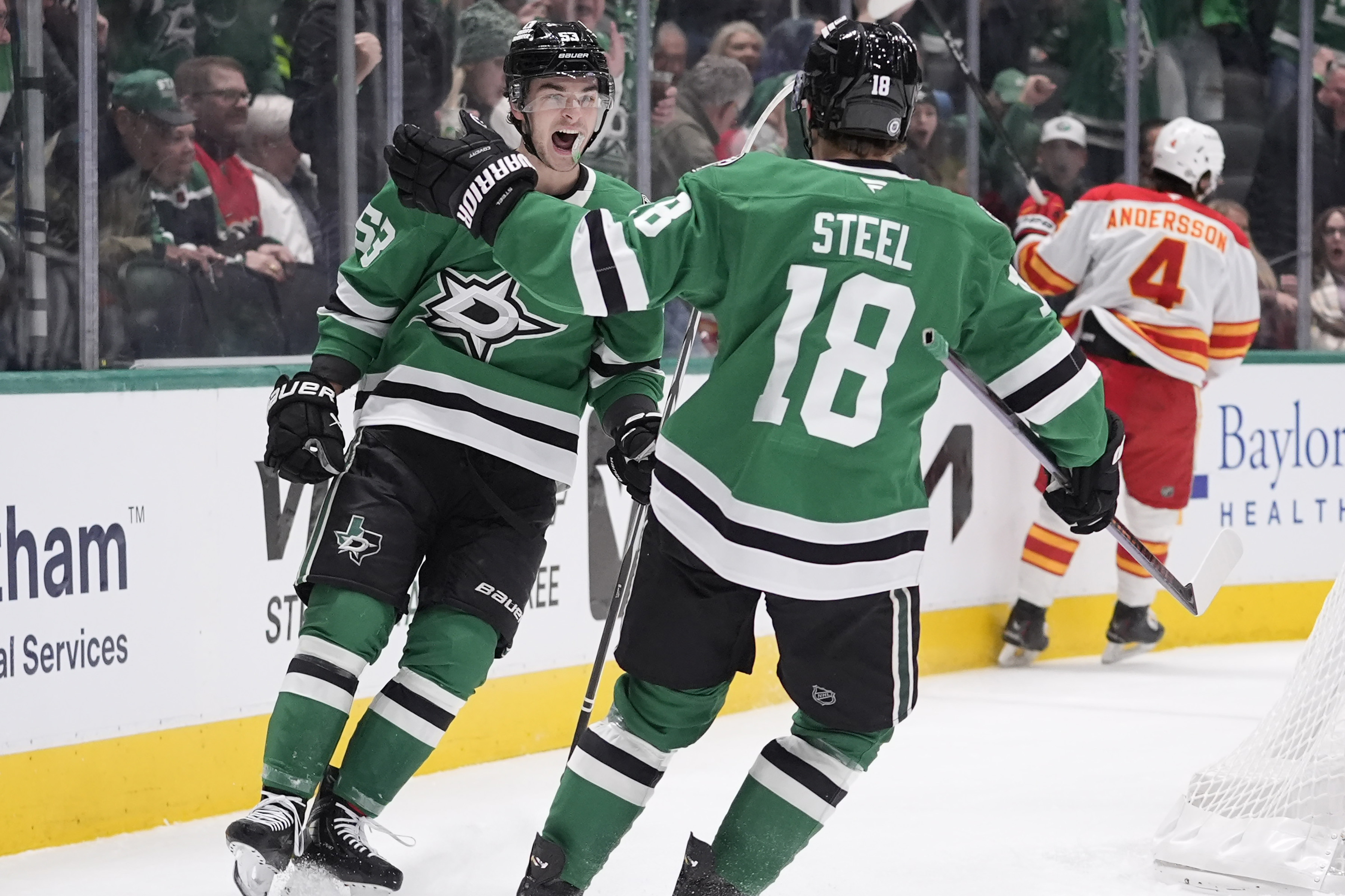 Dallas Stars center Wyatt Johnston (53) celebrates with teammate Sam Steel (18) after his goal against Calgary Flames defenseman Rasmus Andersson (4) during the first period of an NHL hockey game Sunday, Dec. 8, 2024, in Dallas.