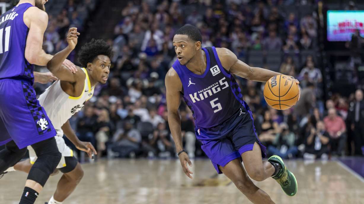 Sacramento Kings guard De'Aaron Fox (5) drives to the basket as Kings forward Domantas Sabonis (11) sets a pick against Utah Jazz guard Collin Sexton, second from left, during the first half of an NBA basketball game Sunday, Dec. 8, 2024, in Sacramento, Calif.