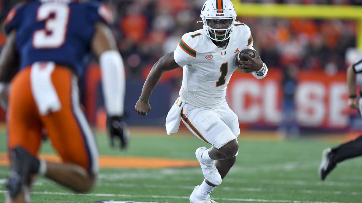Miami quarterback Cam Ward (1) runs with the ball during the first half of an NCAA college football game against Syracuse on Saturday, Nov. 30, 2024 in Syracuse, N.Y.
