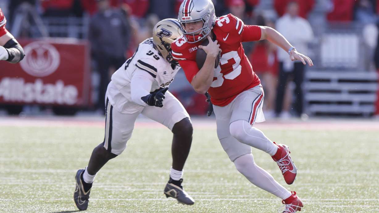 Ohio State quarterback Devin Brown, right, scrambles away from Purdue defensive lineman Jireh Ojata during the second half of an NCAA college football game Saturday, Nov. 9, 2024, in Columbus, Ohio.