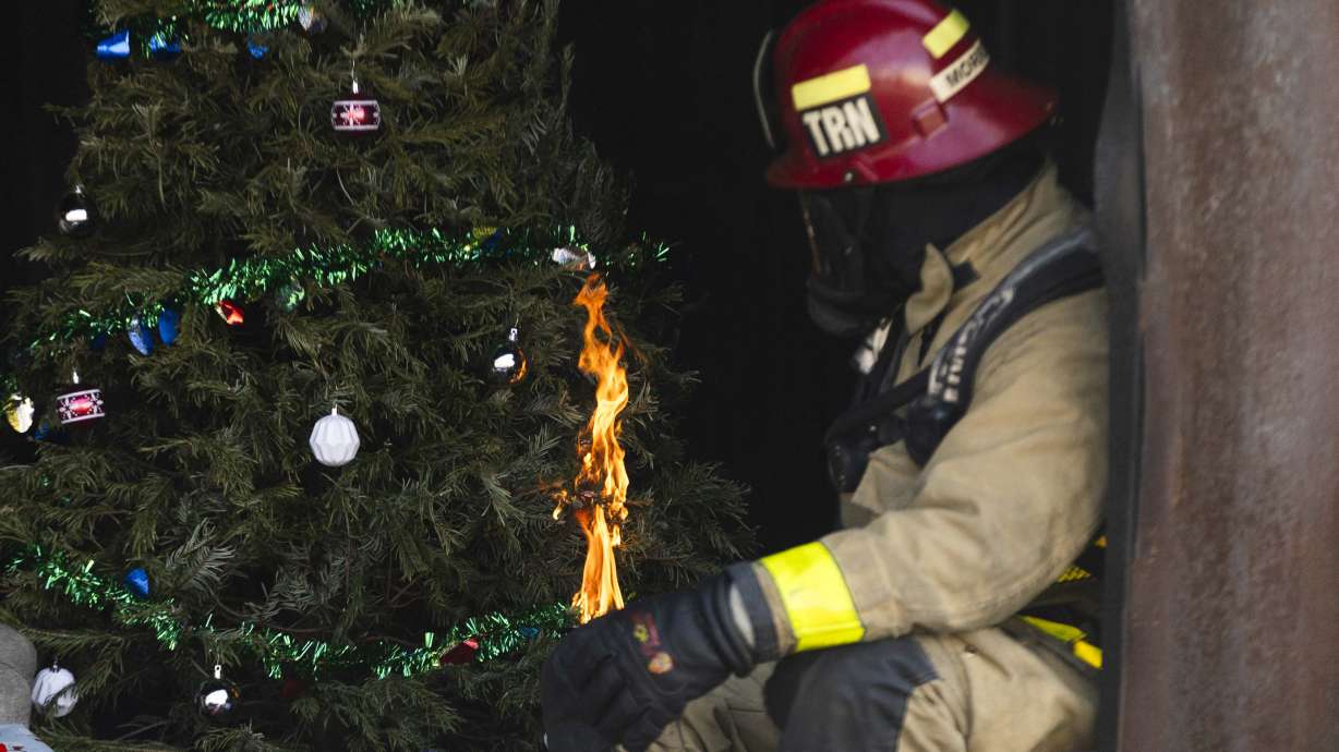Salt Lake Fire Capt. Justin Morrow sets a Christmas tree on fire with a candle during a fire safety demonstration at the Salt Lake City Fire Training Center in Salt Lake City on Monday.