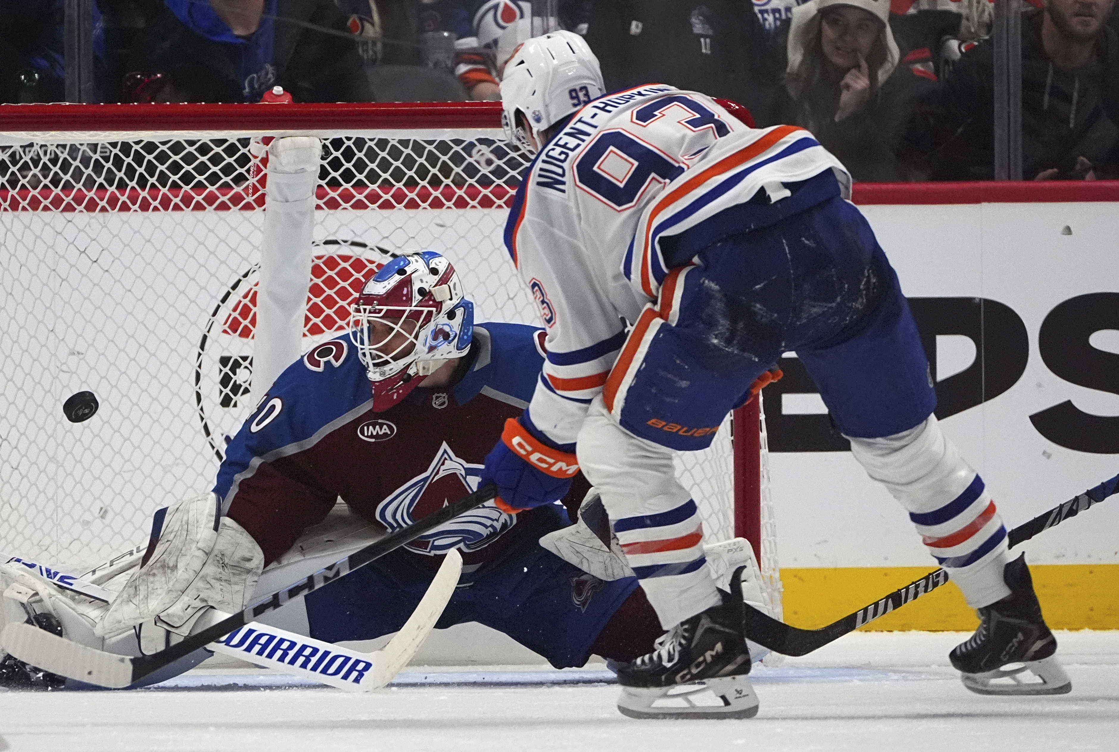 Edmonton Oilers center Ryan Nugent-Hopkins, front, puts a shot on Colorado Avalanche goaltender Alexandar Georgiev in the third period of an NHL hockey game Saturday, Nov. 30, 2024, in Denver.