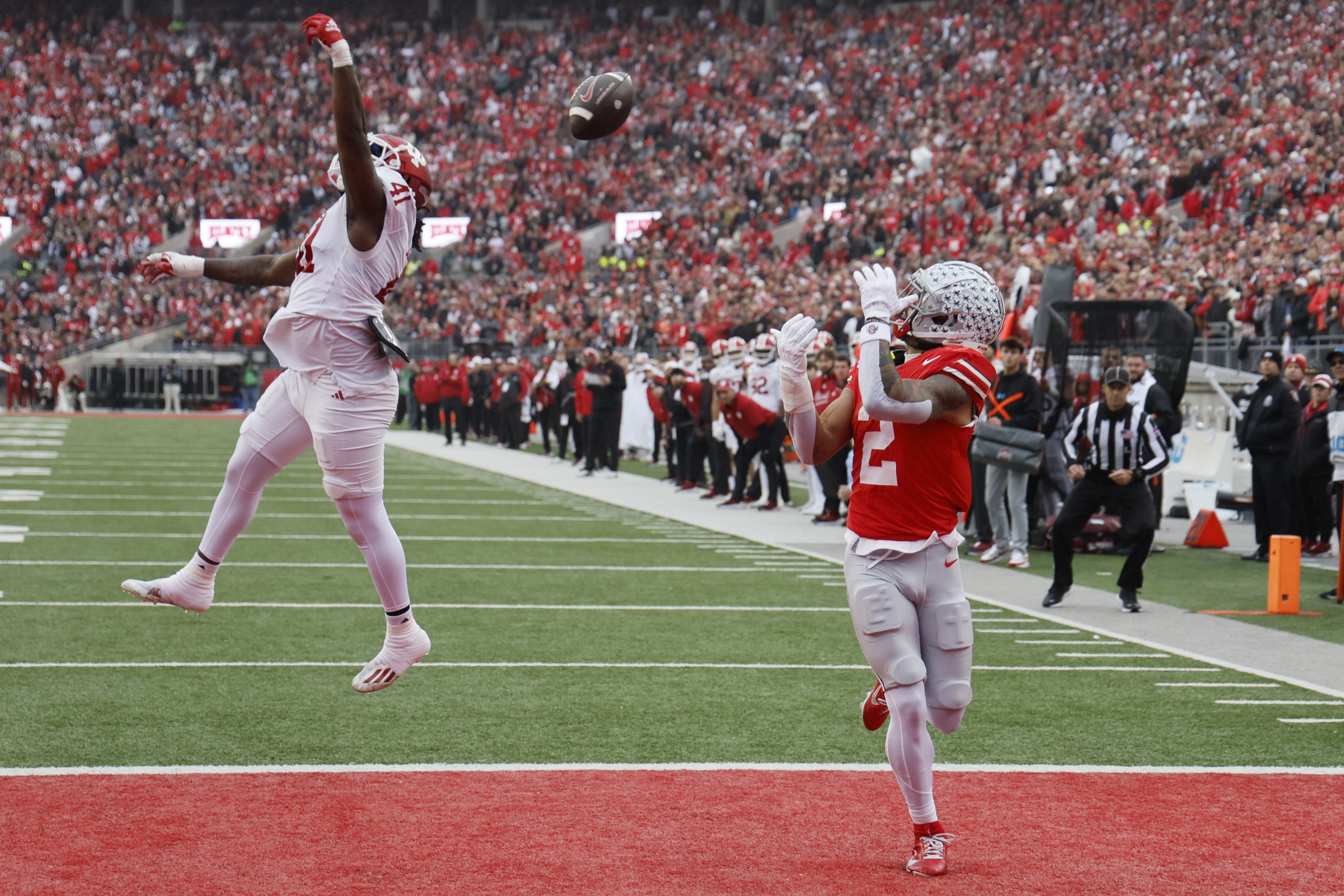 Ohio State receiver Emeka Egbuka, right, catches a touchdown pass thrown over Indiana defensive lineman Lanell Carr during the first half of an NCAA college football game Saturday, Nov. 23, 2024, in Columbus, Ohio.