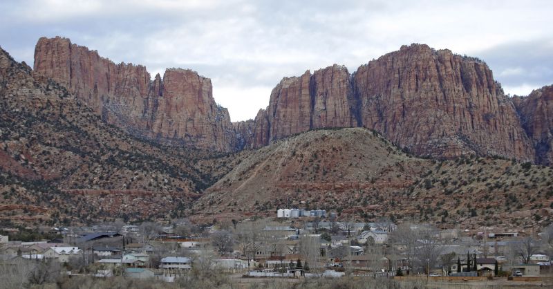 This photo shows Hildale sitting at the base of Red Rock Cliff mountains, with its sister city, Colorado City, Ariz., in the foreground, Dec. 16, 2014.