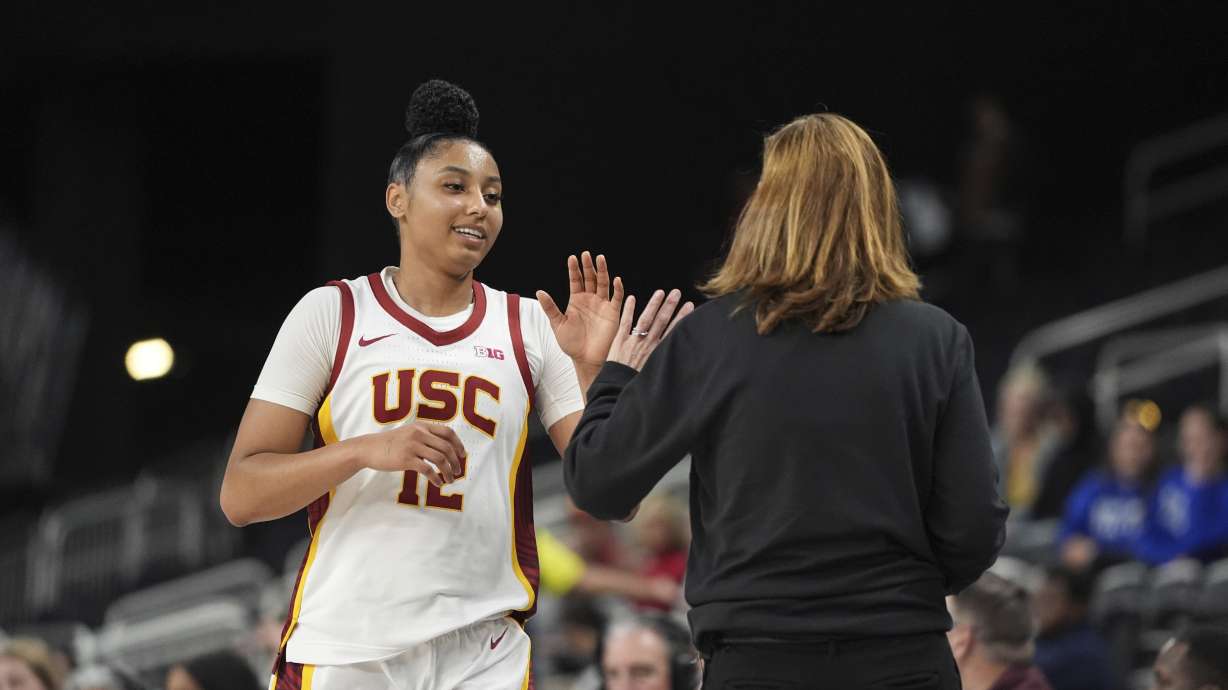 Southern California guard JuJu Watkins (12) high-fives head coach Lindsay Gottlieb during the second half of an NCAA women's college basketball game against Seton Hall in Palm Desert, Calif., Wednesday, Nov. 27, 2024.