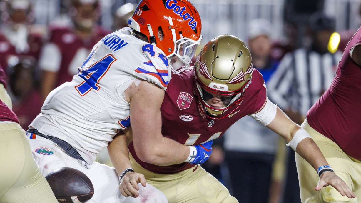 Florida's Jack Pyburn (44) strips the ball from Florida State quarterback Luke Kromenhoek, right, during the first half of an NCAA college football game Saturday, Nov. 30, 2024, in Tallahassee, Fla. Florida recovered the ball.