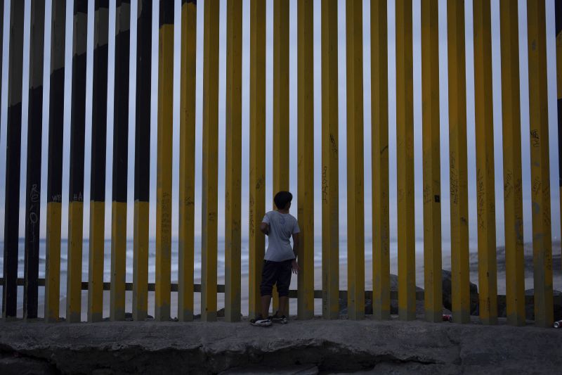 A boy looks through a border wall separating Mexico from the United States, Nov. 26 in Tijuana, Mexico.