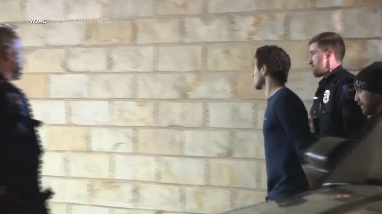 Law enforcement officers escort Luigi Mangione, handcuffed, into a courthouse building in Hollidaysburg, Pa. on Monday.