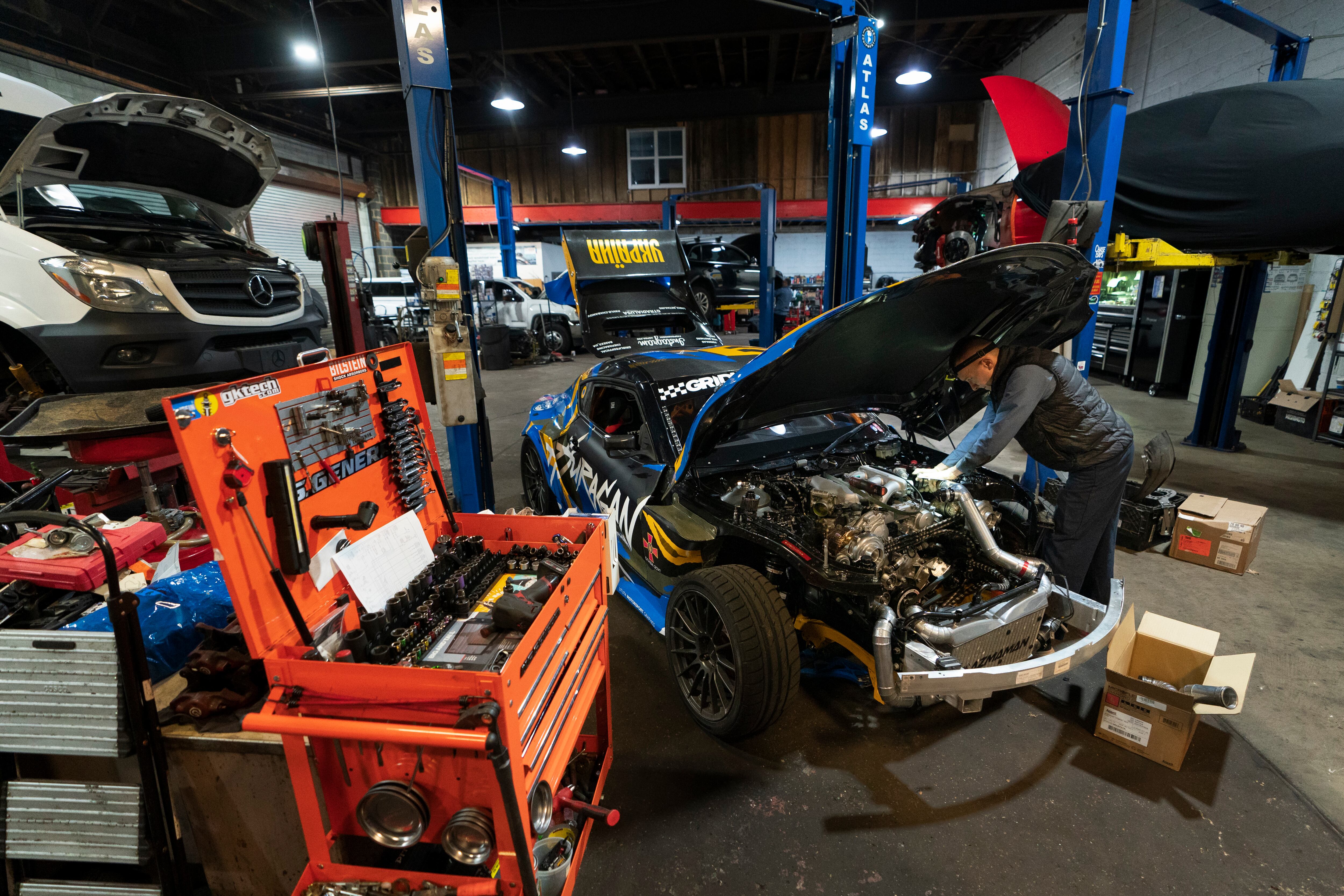 Mechanic David Stoliaruk works the internal combustion engine of a car at IC Auto in Philadelphia, May 2, 2023. The EPA this week announced bans on two chemicals used in home and workplace settings.