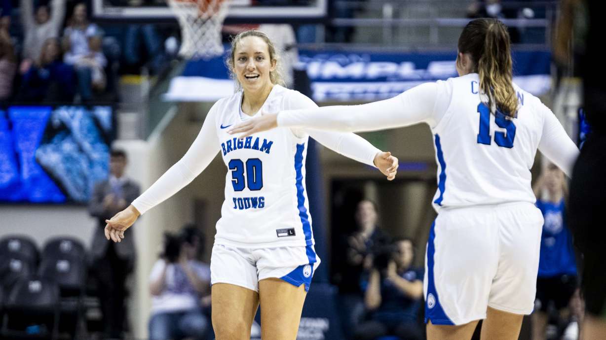 Brigham Young guard Lauren Davenport (30) slaps hands with Brigham Young guard Kemery Congdon (15) after Davenport hit a 3-pointer to end the first quarter during an NCAA women’s basketball game between the BYU Cougars and the UVU Wolverines held at the Marriott Center in Provo on Tuesday, Dec. 10, 2024.