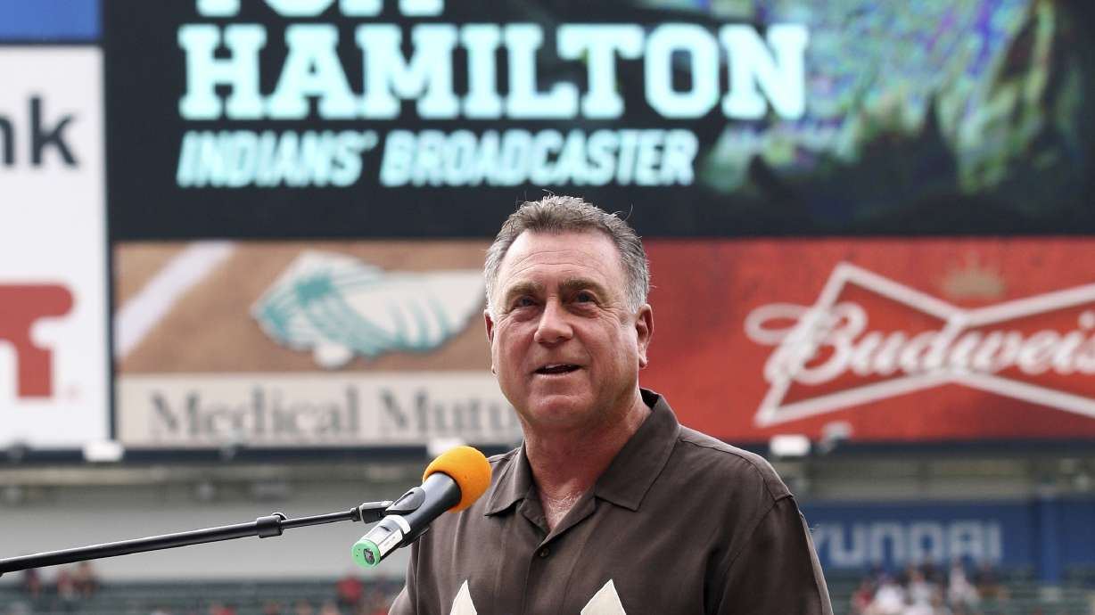 FILE - Cleveland Indians radio announcer Tom Hamilton talks after being honored for 25 years of broadcasting, prior to the Indians' baseball game against the Texas Rangers, Friday, Aug. 1, 2014, in Cleveland.