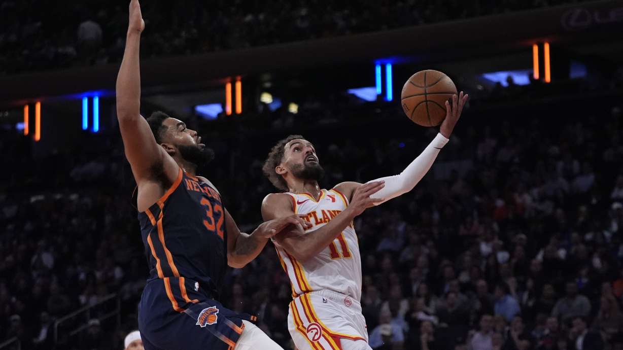 Atlanta Hawks' Trae Young (11) drives past New York Knicks' Karl-Anthony Towns (32) during an Emirates Cup NBA basketball game Wednesday, Dec. 11, 2024, in New York.