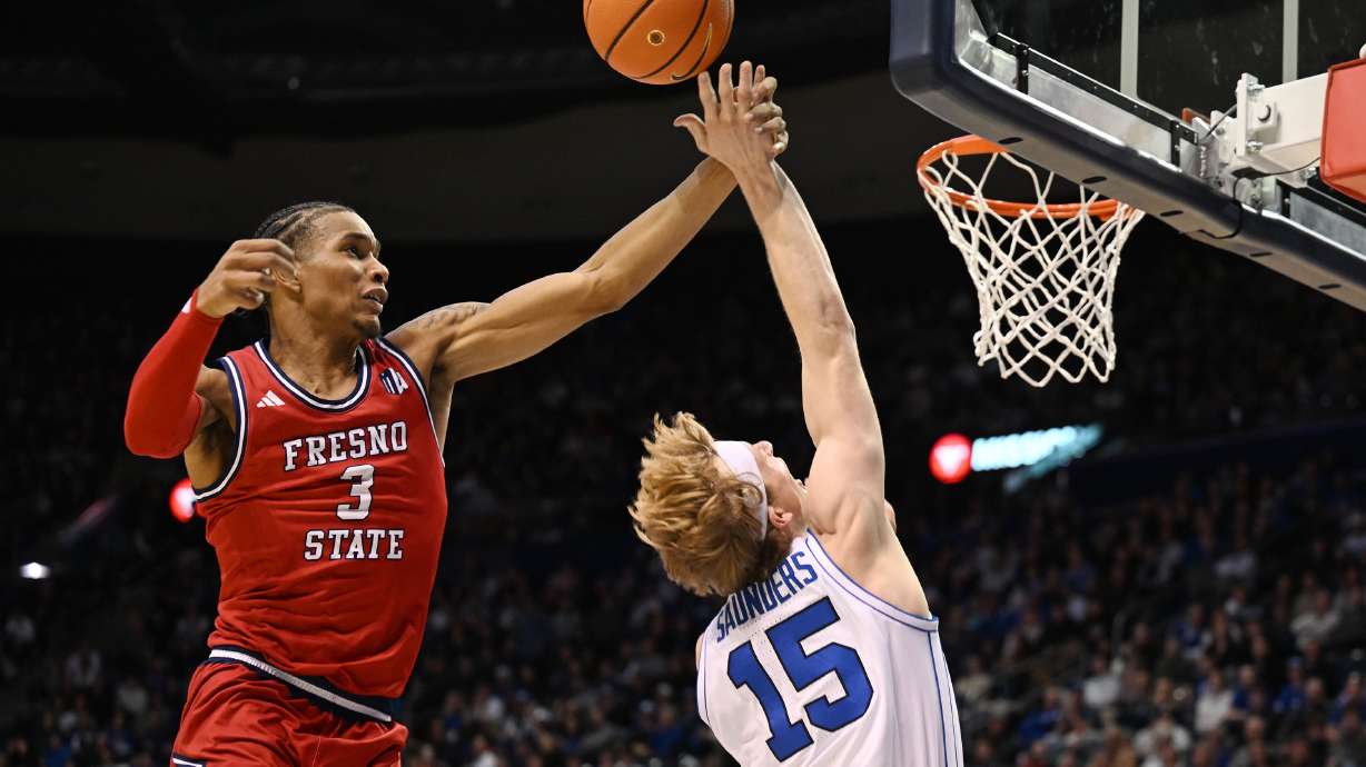 Fresno State forward Elijah Price (3) fouls Brigham Young forward Richie Saunders (15) as BYU and Fresno State play at the Marriott Center in Provo on Wednesday Dec. 11, 2024.