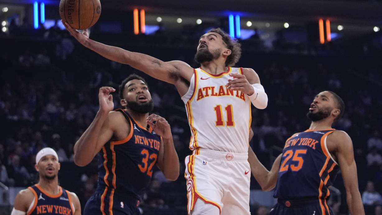 Atlanta Hawks' Trae Young (11) drives past New York Knicks' Mikal Bridges (25), Karl-Anthony Towns (32) and Josh Hart (3) during the first half of an Emirates NBA Cup basketball game Wednesday, Dec. 11, 2024, in New York.