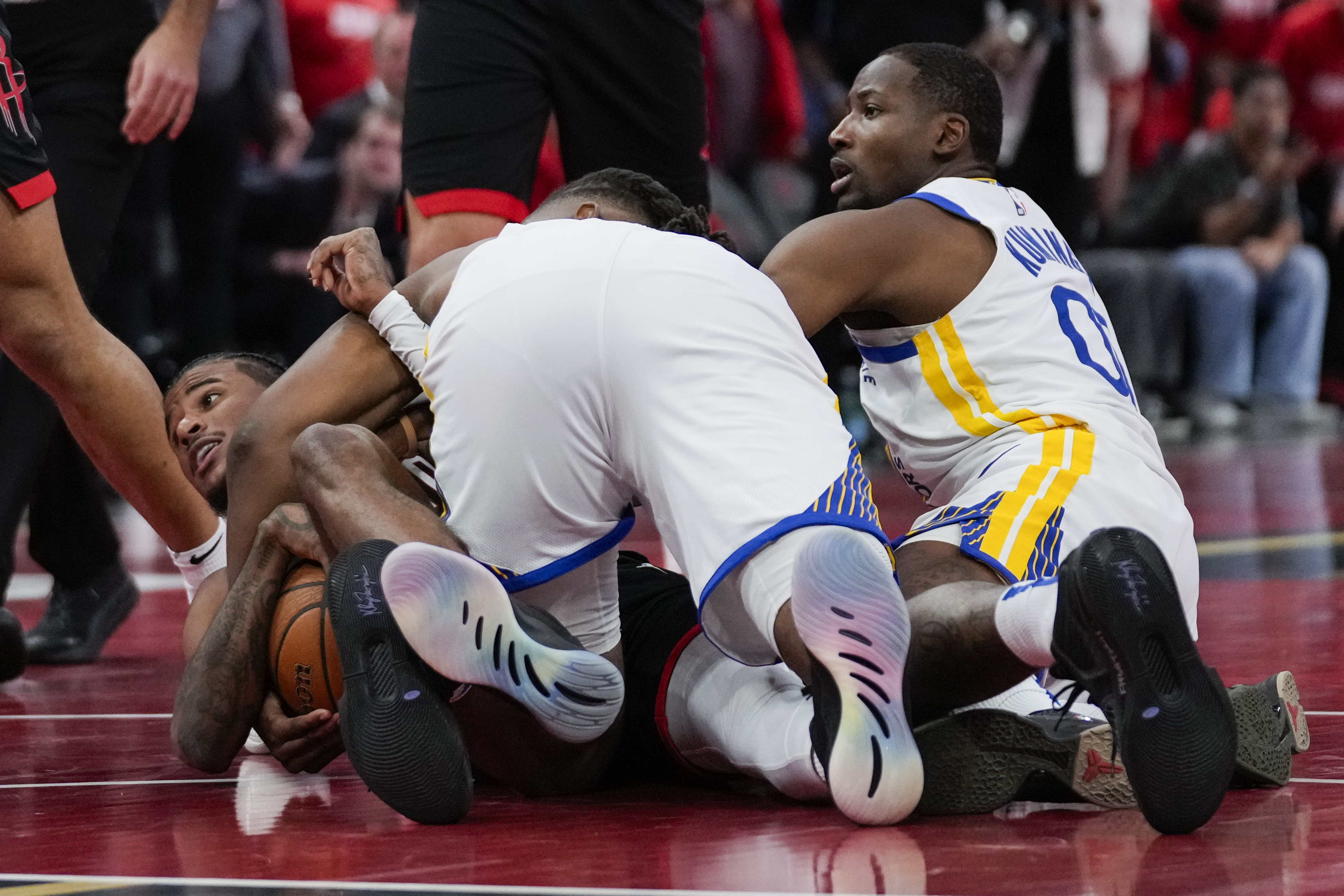 Golden State Warriors forward Jonathan Kuminga (00) fouls Houston Rockets guard Jalen Green, left, during the second half of an Emirates NBA cup tournament quarterfinal basketball game in Houston, Wednesday, Dec. 11, 2024.