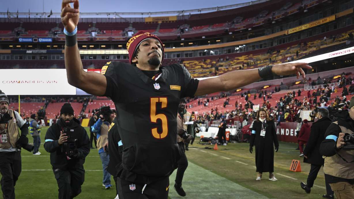 Washington Commanders quarterback Jayden Daniels (5) celebrates the team's 42-19 win against the Tennessee Titans in an NFL football game Sunday, Dec. 1, 2024, in Landover, Md.