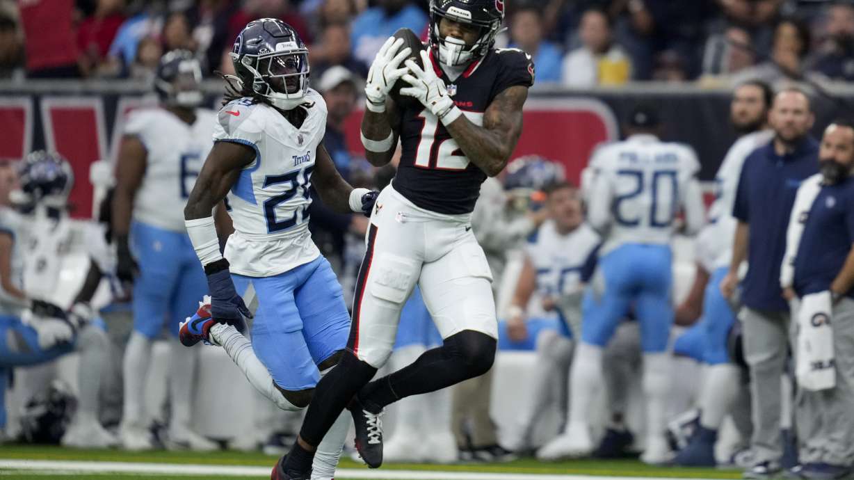 Houston Texans wide receiver Nico Collins (12) makes a catch past Tennessee Titans cornerback Jarvis Brownlee Jr., left, during the first half of an NFL football game Sunday, Nov. 24, 2024, in Houston.