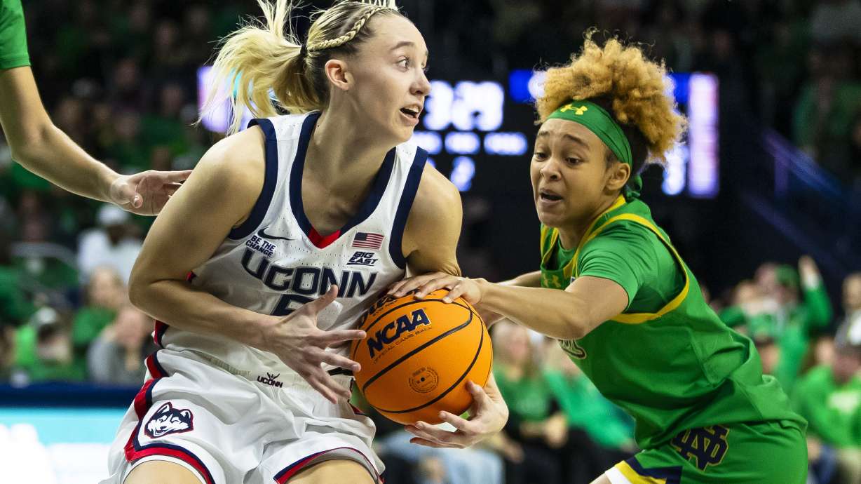 Notre Dame guard Hannah Hidalgo, right, tries to steal the ball from UConn guard Paige Bueckers, left, during the first half of an NCAA college basketball game Thursday, Dec. 12, 2024, in South Bend, Ind.