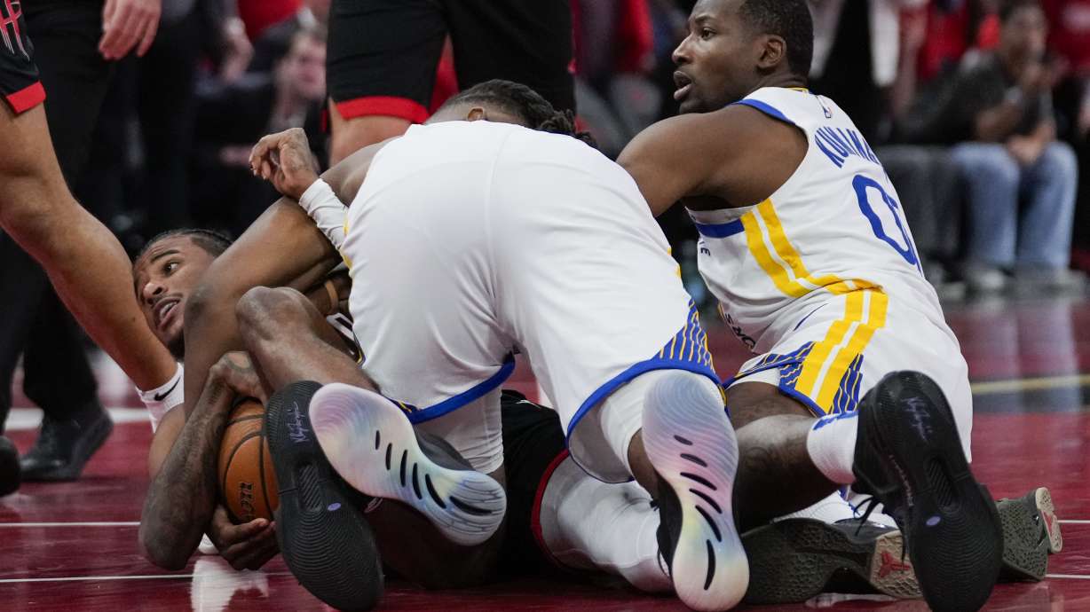 Golden State Warriors forward Jonathan Kuminga (00) fouls Houston Rockets guard Jalen Green, left, during the second half of an Emirates NBA cup tournament quarterfinal basketball game in Houston, Wednesday, Dec. 11, 2024.