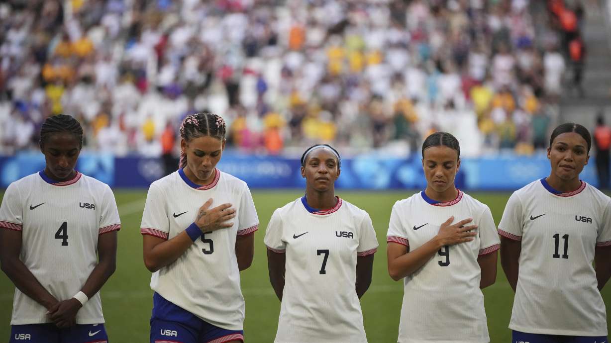FILE - From left; United States' Naomi Girma, Trinity Rodman, Crystal Dunn, Mallory Swanson and Sophia Smith listen to the national anthem ahead of a women's Group B soccer match between Australia and the United States, at the Marseille Stadium during the 2024 Summer Olympics, Wednesday, July 31, 2024, in Marseille, France.