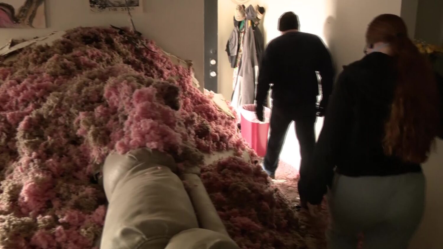 Josef Hardacker and Kelsi Johnson walk through their living room which is filled with insulation on Thursday, after an apartment fire on Monday.