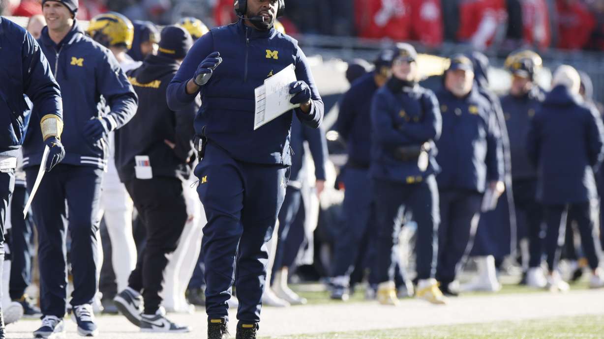 Michigan head coach Sherrone Moore, front, watches his team play against Ohio State during the second half of an NCAA college football game Saturday, Nov. 30, 2024, in Columbus, Ohio.