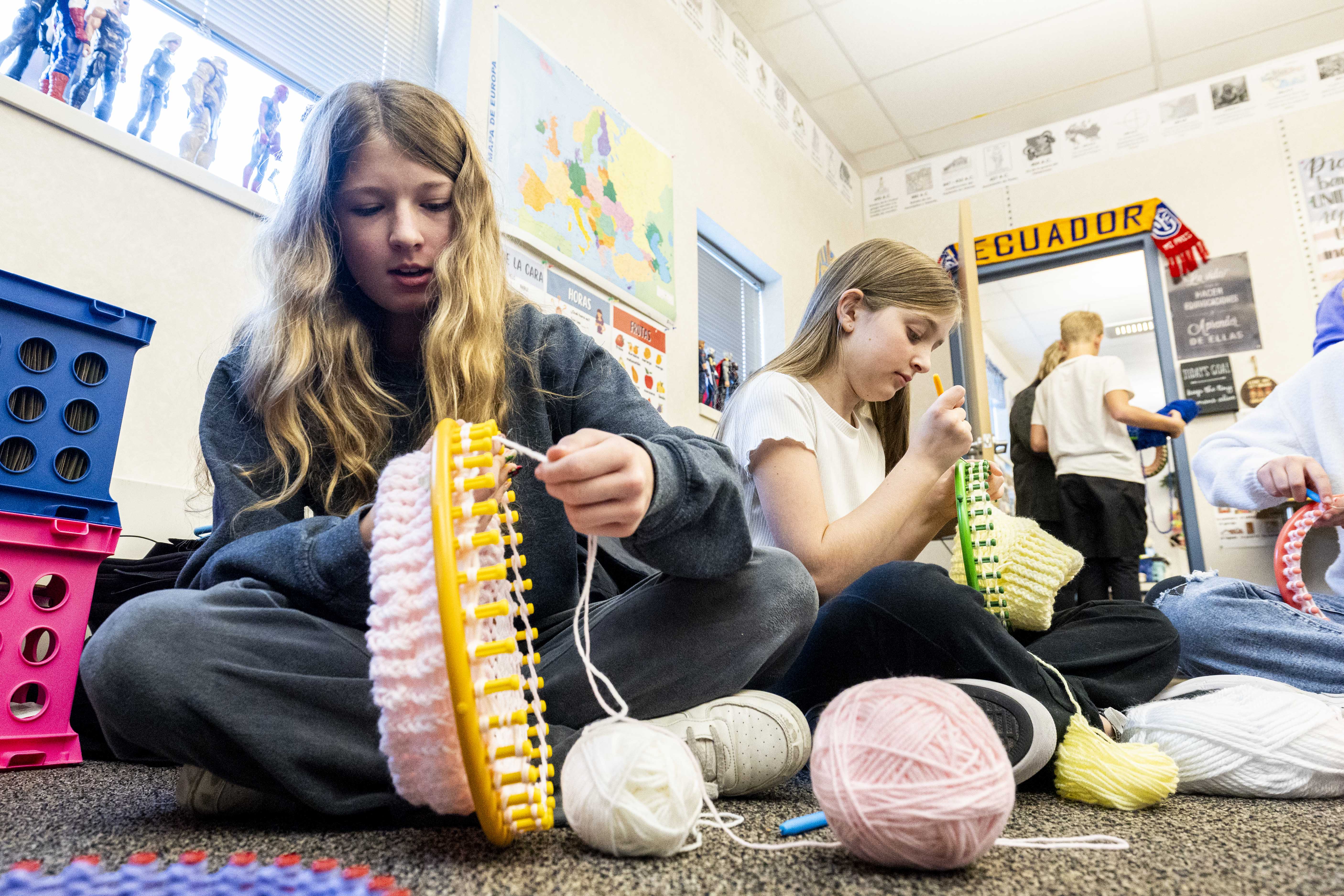 Sixth grader Chelsea Hutchinson, left, uses a loom to create a hat as part of the Warming Hearts and Heads in Ecuador service project at Eagle Bay Elementary School in Farmington on Wednesday.