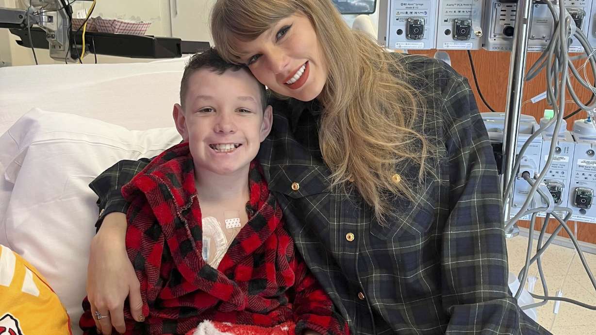 In this image provided by Cassie Thomas, Beckett Thomas, 13, who is a patient at Children's Mercy Hospital in Kansas City, Mo., poses with Taylor Swift, Thursday, Dec. 12, 2024.