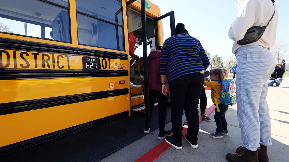 Teachers help students onto an electric school bus at Parkview Elementary School in Salt Lake City on April 12, 2021. The Utah Division of Air Quality on Friday was announced as the recipient of a $60 million grant to help electrify transportation.