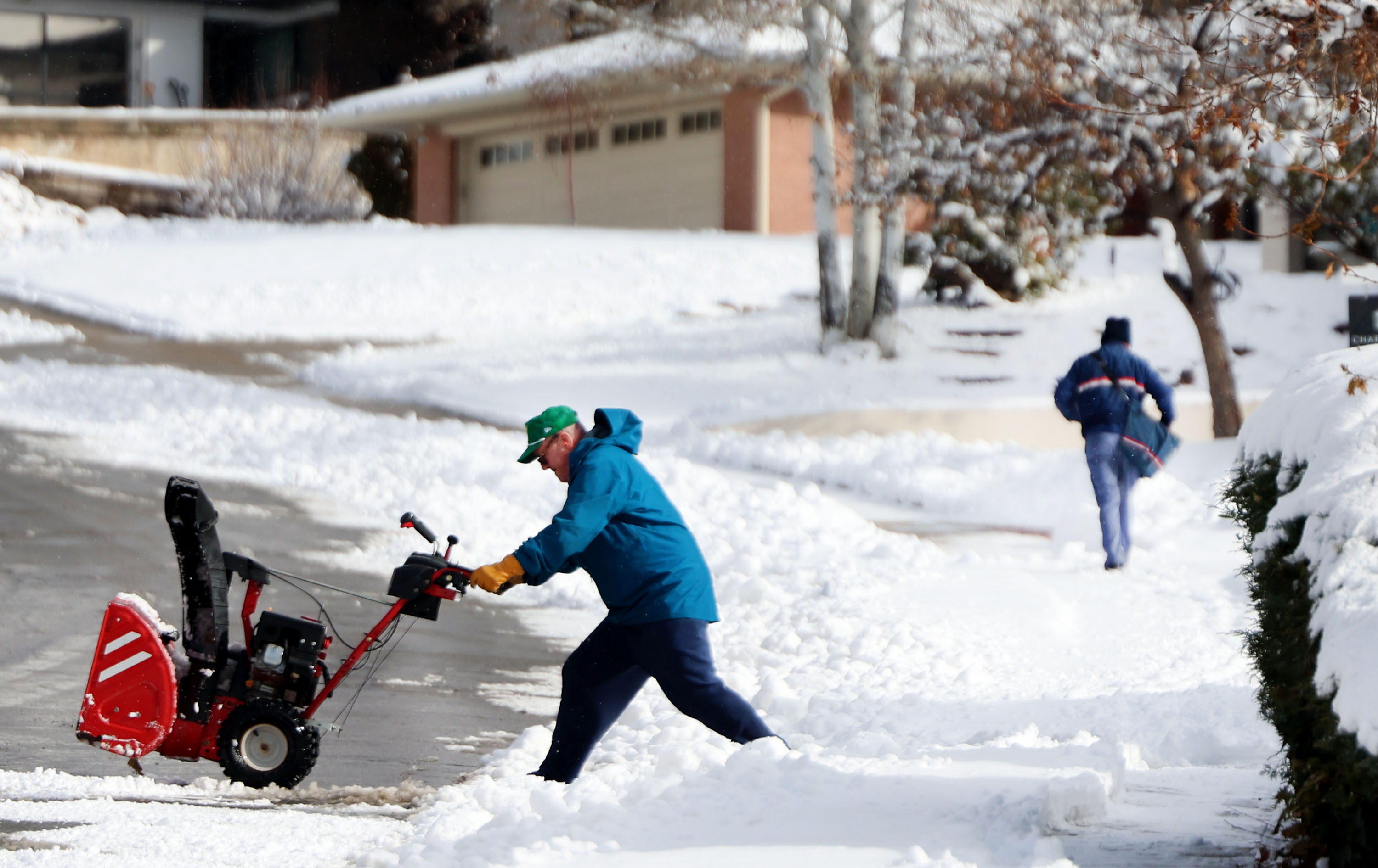 Sidewalks and driveways are cleared of snow as city carrier Gene Gonzales works his route in the Millcreek area on Friday.