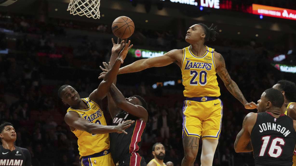 Los Angeles Lakers forward Maxwell Lewis (20) and center Christian Koloko defend Miami Heat center Thomas Bryant during the second half of an NBA basketball game, Wednesday, Dec. 4, 2024, in Miami.