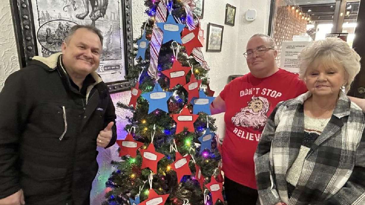 Sylvio Pizzaia, Nikki Watterson, and Judith Cooley next to the veterans' Christmas tree at Bundy's Brazilian Steakhouse in St. George.
