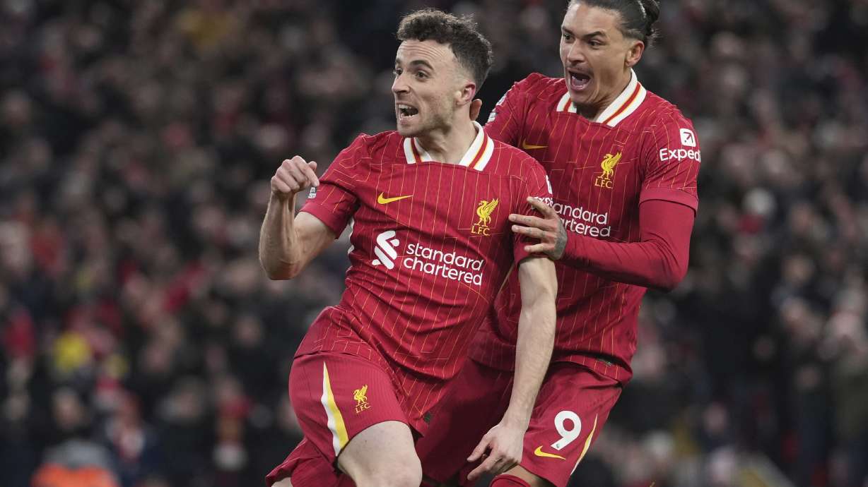 Liverpool's Diogo Jota, left, celebrates with Liverpool's Darwin Nunez after scoring his side's second goal during the English Premier League soccer match between Liverpool and Fulham, at Anfield stadium in Liverpool, England, Saturday, Dec. 14, 2024.