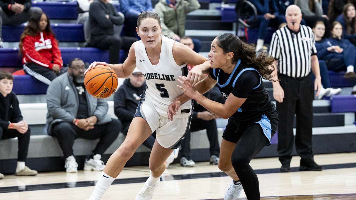Ridgeline guard Emilee Skinner (5) drives the ball while guarded by Riverdale Ridge guard Chloe Parker (24) during a high school girls basketball game as part of Lehi Holiday Hoopfest held at Lehi High School in Lehi on Friday, Dec. 13, 2024.