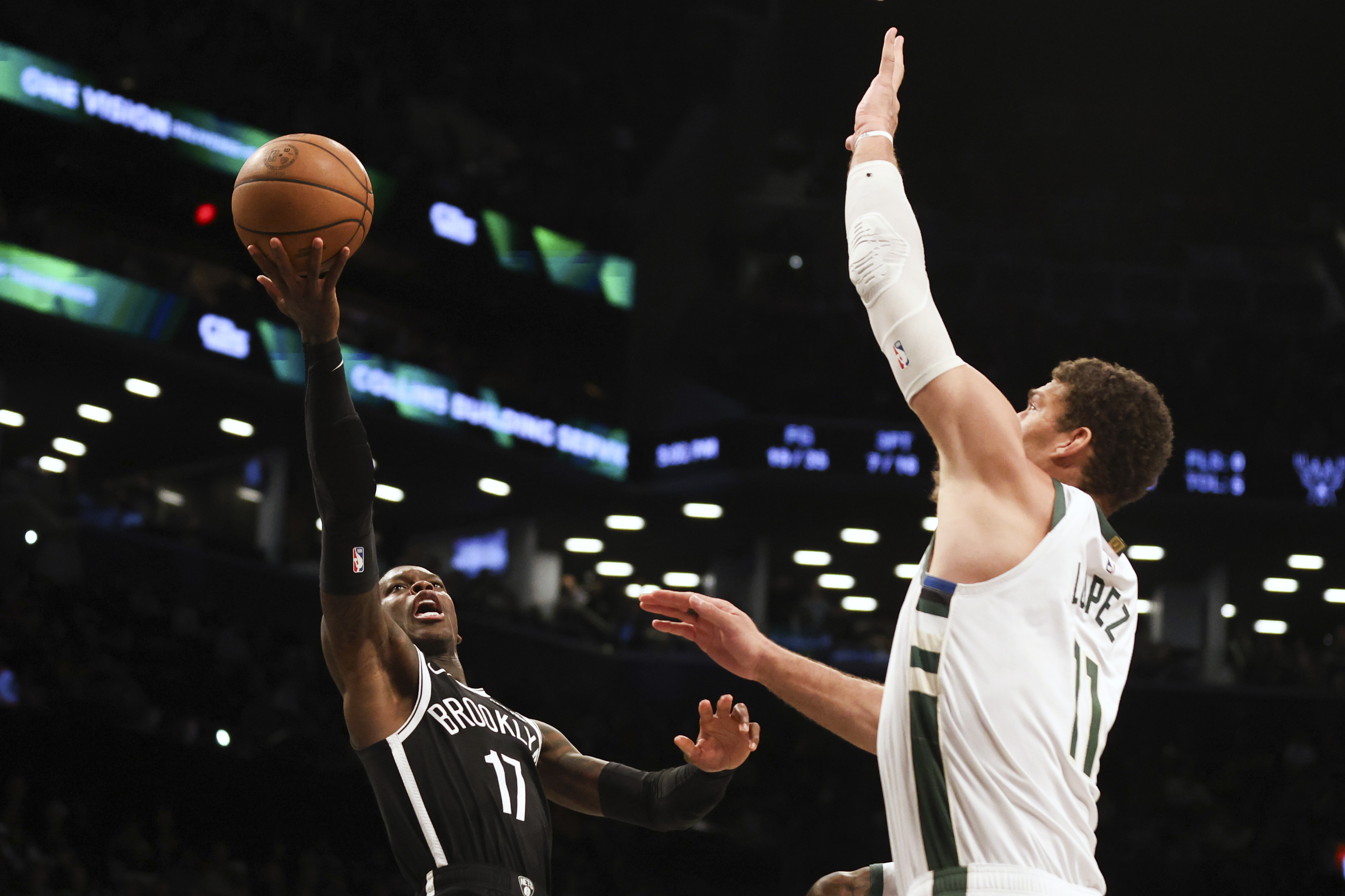 Brooklyn Nets' Dennis Schroder, left, looks to shoots over Milwaukee Bucks' Brook Lopez, right, during the second half of an NBA basketball game, Sunday, Dec. 8, 2024, in New York.