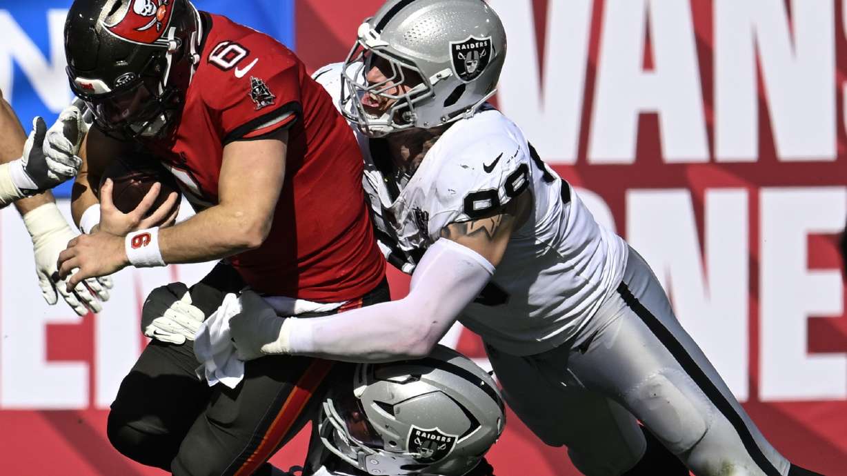 Tampa Bay Buccaneers quarterback Baker Mayfield (6) is sacked by Las Vegas Raiders defensive tackle Adam Butler (69) and defensive end Maxx Crosby (98) during the first half of an NFL football game, Sunday, Dec. 8, 2024, in Tampa, Fla.