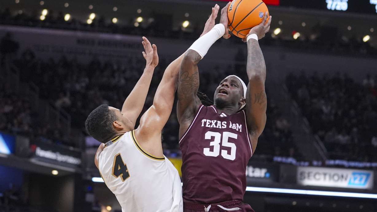 Texas A&M guard Manny Obaseki (35) shoots over Purdue forward Trey Kaufman-Renn (4) in the second half of an NCAA college basketball game in Indianapolis, Saturday, Dec. 14, 2024.