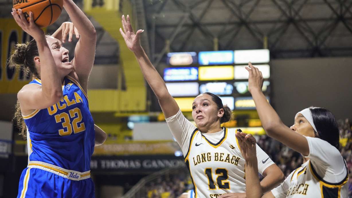 UCLA forward Angela Dugalic (32) scores against Long Beach State forward Mykelle Richards (22) and Long Beach State center Haley Wright (33) during the second half of an NCAA college basketball game in Long Beach, Calif., Saturday, Dec. 14, 2024.