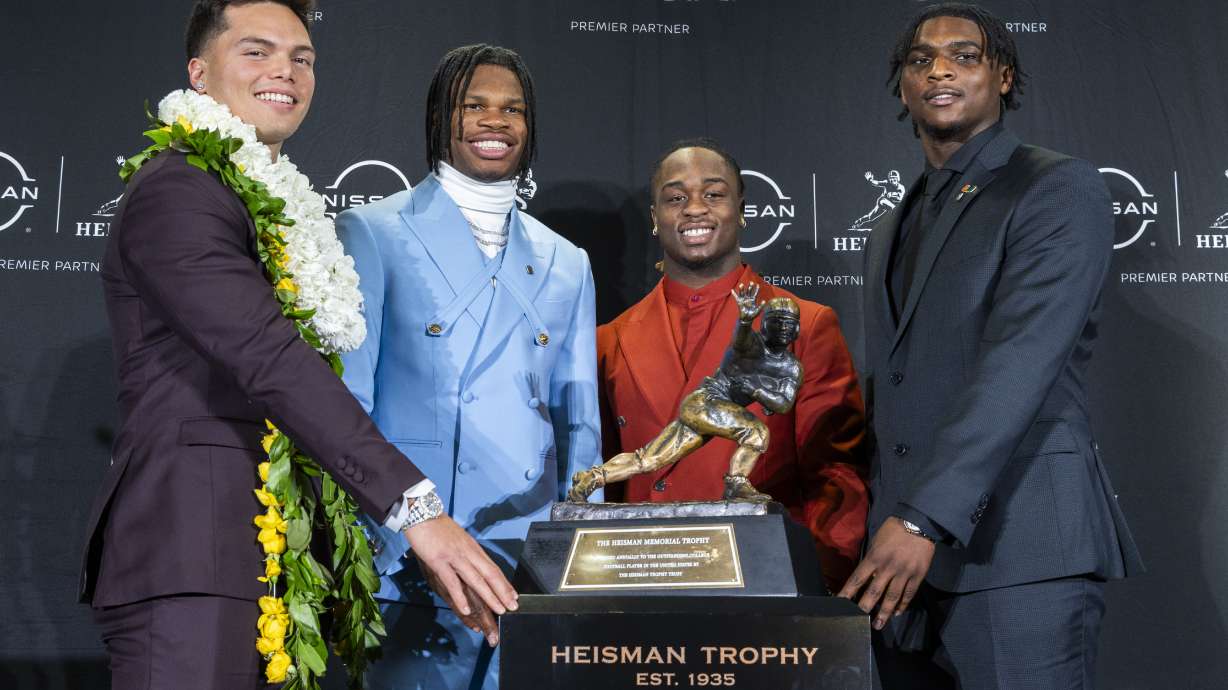 Heisman Trophy finalists, from left, Oregon's Dillon Gabriel, Colorado's Travis Hunter, Boise State's Ashton Jeanty and Miami's Cam Ward pose with the trophy during a college football press conference, Saturday, Dec. 14, 2024, in New York.
