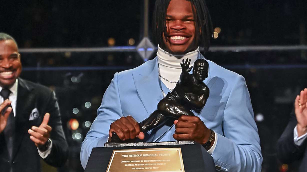 Colorado’s Travis Hunter holds the trophy after winning the Heisman Trophy as the outstanding player in college football, Saturday, Dec. 14, 2024, in New York.
