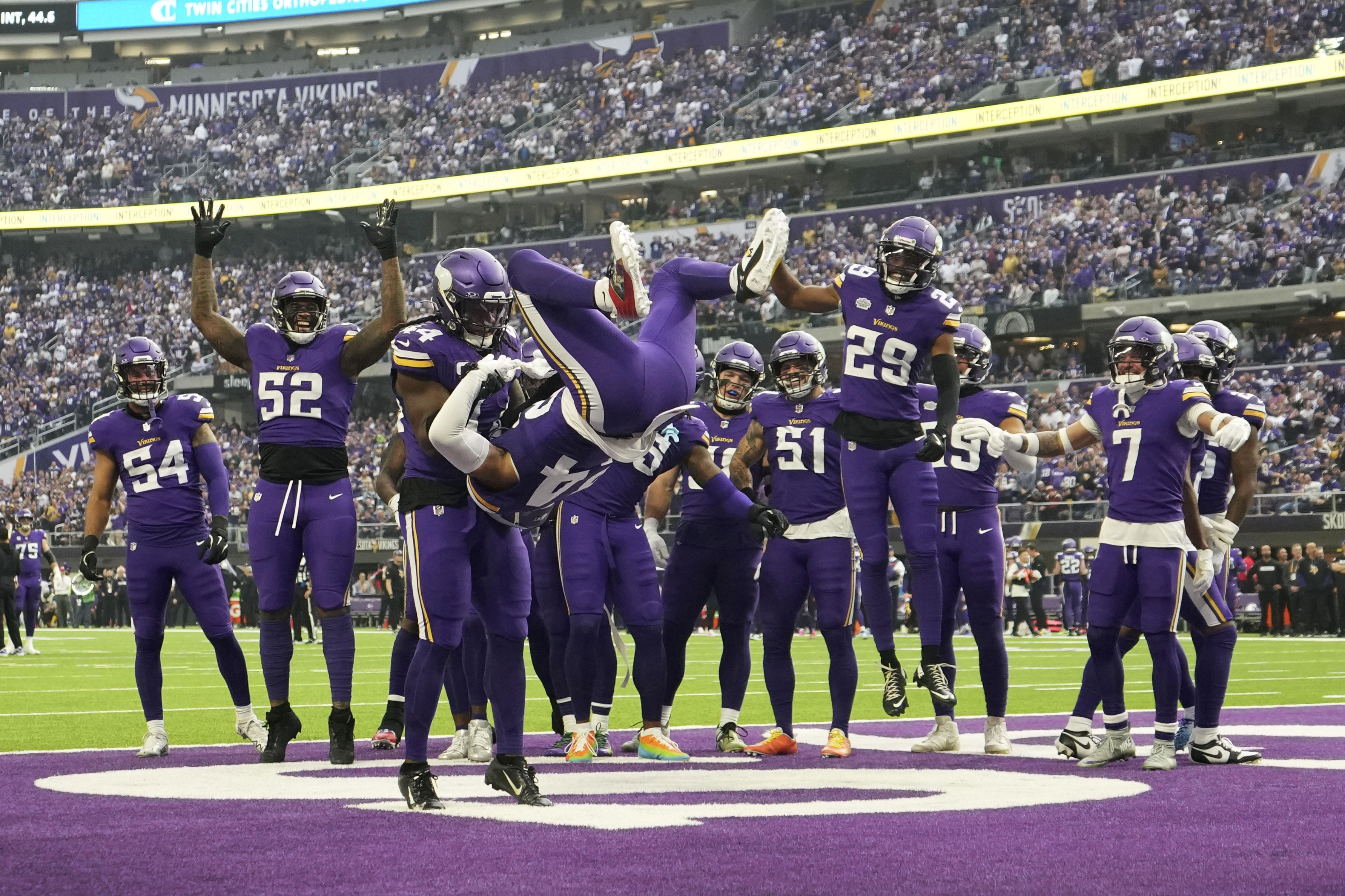 Minnesota Vikings safety Camryn Bynum (24) does a backflip as he celebrates with teamamtes after an interception by Vikings safety Josh Metellus (44) during the first half of an NFL football game against the Atlanta Falcons, Sunday, Dec. 8, 2024, in Minneapolis.