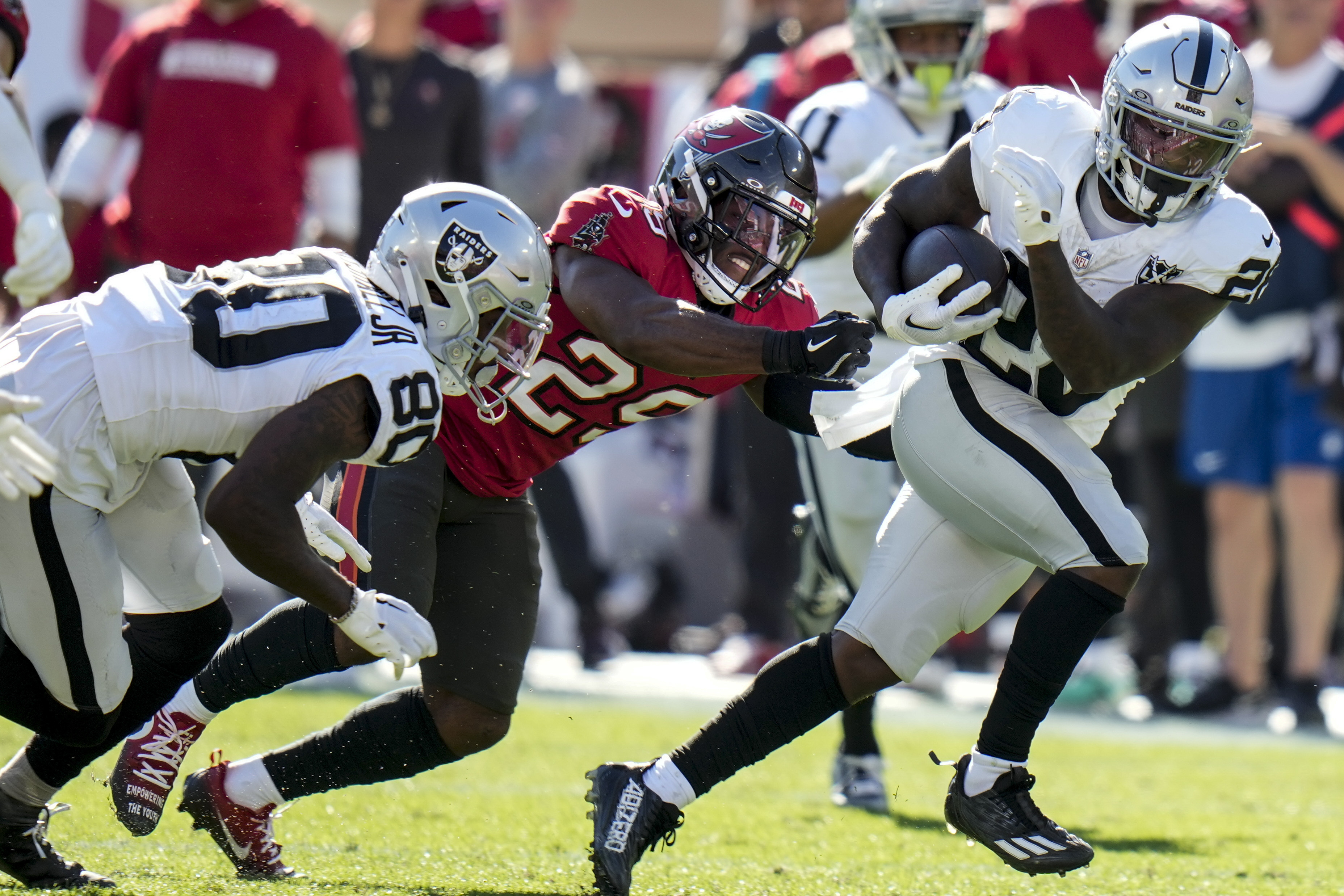 Las Vegas Raiders running back Sincere McCormick (28) runs against Tampa Bay Buccaneers safety Christian Izien (29) during the first half of an NFL football game, Sunday, Dec. 8, 2024, in Tampa, Fla.