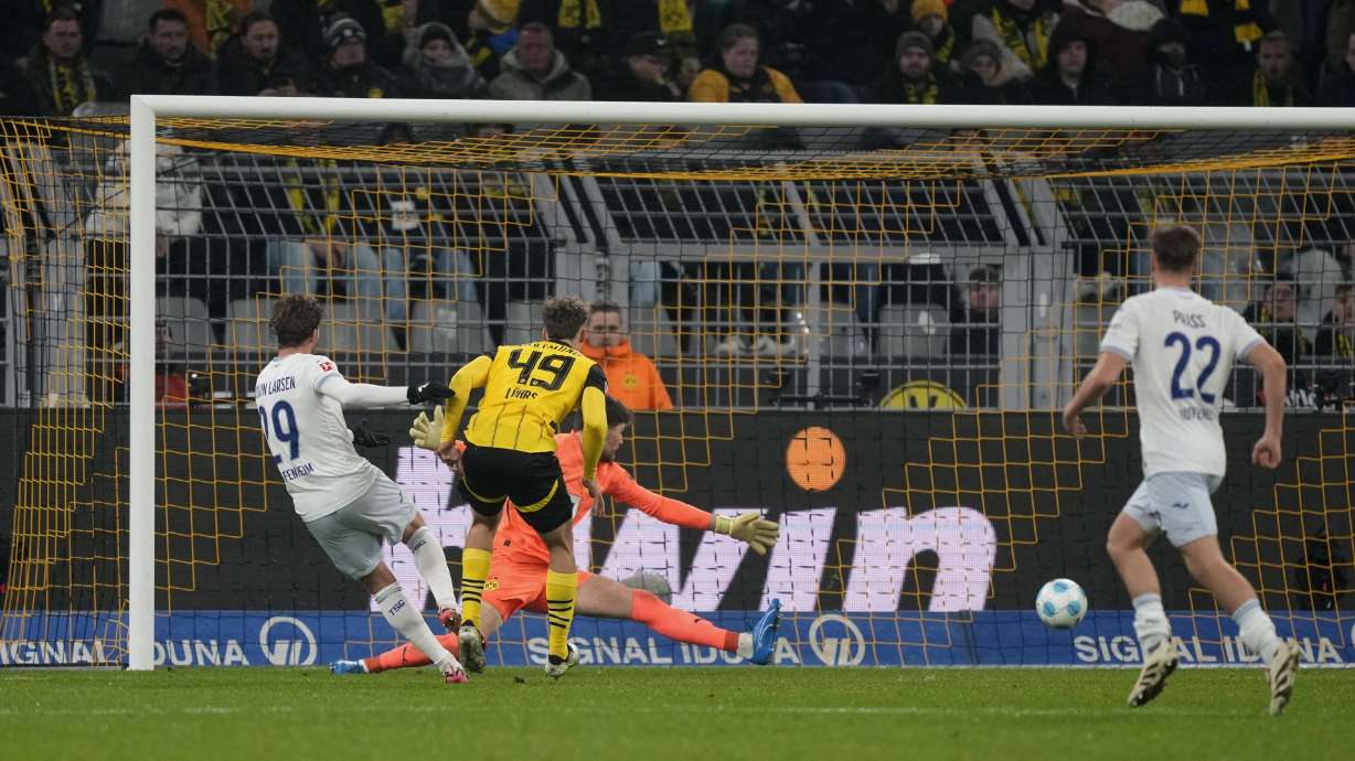 Hoffenheim's Jacob Bruun Larsen, left, scores his side's first goal during the German Bundesliga soccer match between Borussia Dortmund and TSG Hoffenheim at the Signal-Iduna Park in Dortmund, Germany, Sunday, Dec. 15 2024.