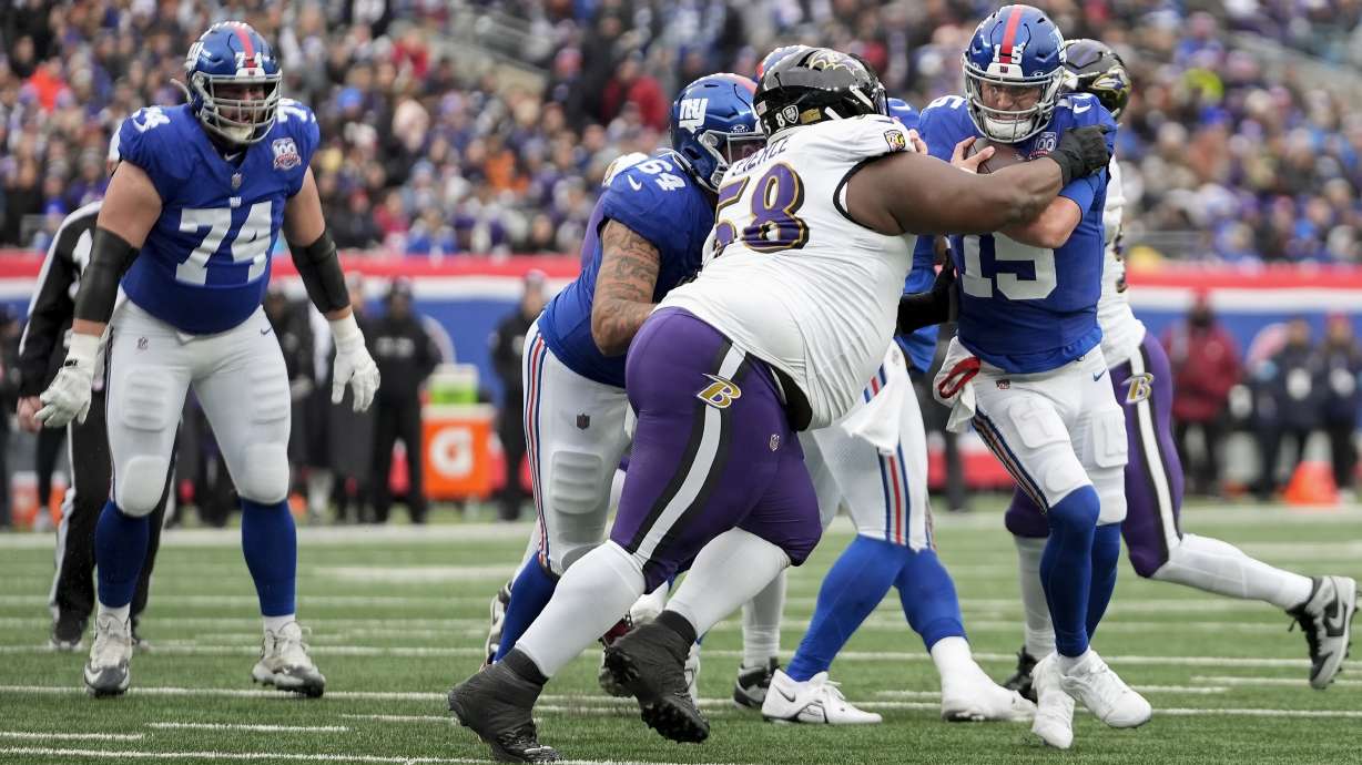 New York Giants quarterback Tommy DeVito (15) loses yards against Baltimore Ravens defensive tackle Michael Pierce (58) during the second quarter of an NFL football game, Sunday, Dec. 15, 2024, in East Rutherford, N.J.