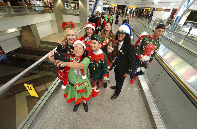 United Airlines employees pose for a photograph as they wait for participants during the company's annual "fantasy flight" to a fictional North Pole at Denver International Airport, Saturday in Denver.