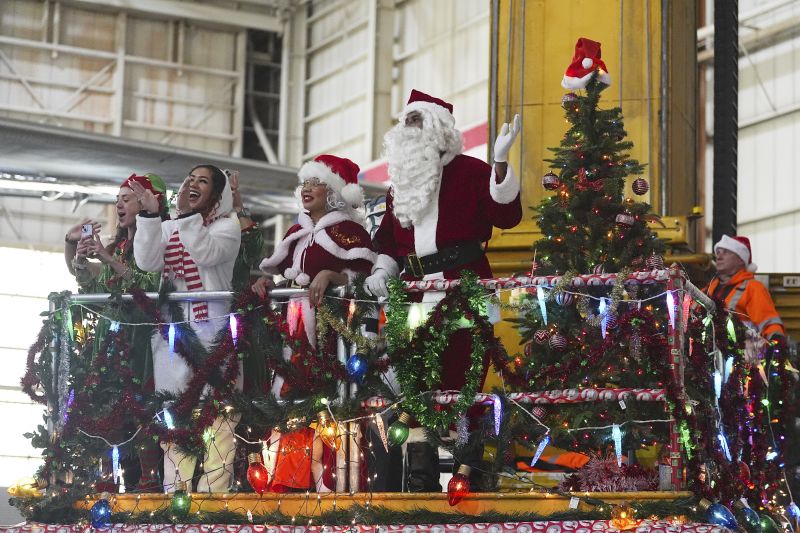 Santa Claus and Mrs. Claus greet participants as they disembark from a plane during the United Airlines annual "fantasy flight" to a fictional North Pole at Denver International Airport, Saturday in Denver.